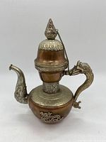 Front view of vintage copper percolator with ornate silver metalwork and dragon motif