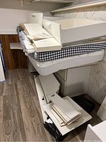 Disassembled white bed frame panels stacked on two mattresses in basement room