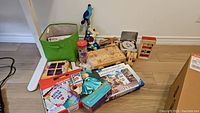 Photo showing the collection of kids toys including wooden toys, puzzles, and a green storage bin