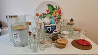 Overview of kitchenware items including decorative platter, glass jars, mugs, and other containers