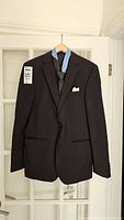 Black Hugo Boss suit coat hanging on a wooden hanger, showing full front view.
