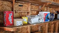 Electric fan, various boxed light bulbs, and smoke absorber on shelf showing lot contents