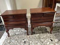 Pair of mahogany side tables shown from front with drawers closed