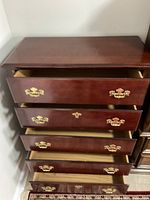 Close-up angle showing the open drawers, brass handles, and interior drawer space of the mahogany wood dresser.