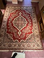 Rug laid out on floor showing full floral pattern, central medallion, and border design.