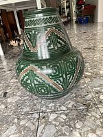 Clear front and side views of a large green ceramic floor vase showing its shape, decorative pattern and finish.