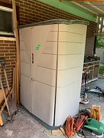 Front side view of Rubbermaid plastic garden shed showing the double swing doors and overall shape.