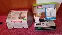 Photo showing the Maxtor OneTouch II external hard drive box alongside the D-Link AC750 WiFi range extender box and Staples EasyTech packaging, both items untested.
