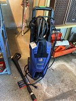 Front view of the Simoniz power washer with handle, hose, and spray wand attached and coiled.