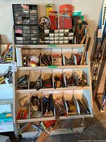 Full organizer shelving unit with multiple labeled bins containing assorted hardware and tools