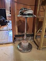 Vintage metal stand ashtray approximately 29 inches tall with glass and ceramic ashtrays on top, shown in an indoor setting.