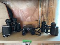 Three binoculars including Carl Zeiss 6x30, Bushnell Ensign Zoom with case, HV Clement 8x32.
