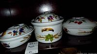 Photo showing three Evasham serving bowls with closed lids, each with different fruit designs and gold handles on sides.