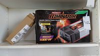 Front view of the boxed MotoMaster Eliminator power inverter on shelf showing branding, power rating, and product image.