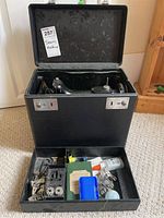 Open case with sewing machine in upper compartment and accessories in lower compartment
