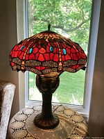 Full front view of lamp lit, showing shade design and base profile