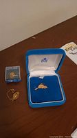 Overview of both gold items displayed on wood surface
