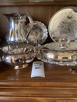Photo showing water pitcher, large bowl, covered serving dish, and serving tray with embossed decorations.