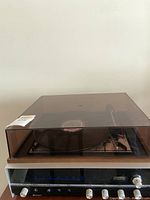Noresco record player with vinyl record and dust cover closed.
