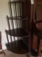 Corner standing shelf showing wood finish and spindle column details from an angle