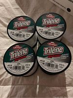 Four spools of Berkley Trilene Big Game 40lb monofilament fishing line lying on a cloth surface showing front labels with weight and yardage.