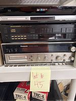 Front view of Sony Blu-ray player, Toshiba DVD player, Marantz CD player, and Panasonic amplifier stacked on shelf with post-it note 'lot #45'.