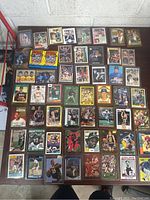 Overview of multiple baseball, basketball, football and Olympic cards laid out on table showing a variety of players and card designs.