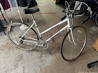 Full side view of the white Panasonic Smart CS vintage racing bike showing the frame, tires, and drop handlebars.