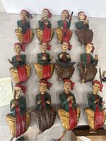 Full view of 12 vintage hand carved wooden Balinese musician figurines arranged in rows, showing variety of instruments and poses.