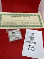 Certificate of authenticity with coin packaged and auction lot number visible.