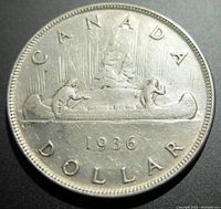 Reverse side of the 1936 Canadian silver dollar coin depicting a canoe with two paddlers and year 1936.