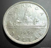 Reverse side of the 1950 Canadian silver dollar coin depicting the voyageur canoe with two paddlers and year 1950, surrounded by inscriptions.