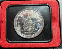 Front view of the 1976 Canada $1 silver commemorative specimen coin in black protective capsule inside red velvet display box.