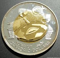 Reverse side of the coin featuring a gold-plated Indigenous figure with a bowl on silver background, labeled NUNAVUT and CANADA 2 DOLLARS.