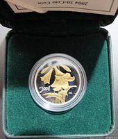 2004 Canadian silver commemorative 50 cents proof coin with gold-colored Easter Lily design in protective capsule inside green display box.