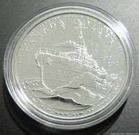 Close-up of the 2010 Canadian silver $1 coin showing ship design and inscriptions.
