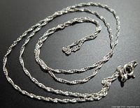 Image shows the full length of the twisted rope style chain necklace laid in a circular pattern with visible clasp and fine detail of chain links.