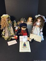 Group photo showing the American Girl Molly doll, Madame Alexander Cinderella doll, additional dolls, doll stands, and certificates.