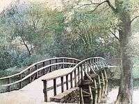 Close-up photo showing partial section of the signed print depicting the curved wooden bridge and trees in natural colors.