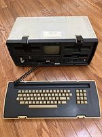 Front view with keyboard detached showing 5″ CRT display, dual 5.25″ floppy drives and keyboard connector