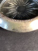 Close-up of silver rim showing engraving Frank M. Whiting & Co Sterling and other markings on coaster rim.