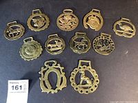 Photo showing 11 vintage brass horse strap medallions with various animal and floral designs