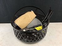 Top down view of unassembled fire pit body containing legs, fuel tank, and hardware packet
