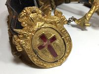 Brass buckle with red enamel cross and ornate Templar crest on leather belt