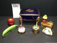 All seven porcelain trinket boxes arranged on dark background