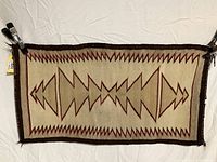 Full front view of entire rectangular weaving pinned against white backdrop