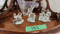 Overall view of three Swarovski crystal figurines; two mice and a seal in a bag