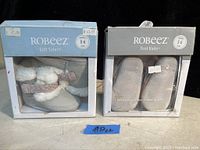 Two boxed pairs of Robeez baby booties: Soft Soles 0-6 months and First Kicks 3-6 months.