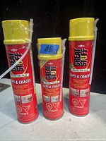 Photo of three cans of Dow Great Stuff foam sealant with yellow caps and red labels indicating use for gaps and cracks.