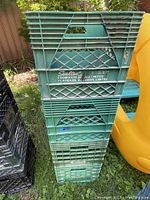 Photo of stacked green plastic milk crates featuring Sealtest Dominion Dairy Limited logo, showing general condition and branding.